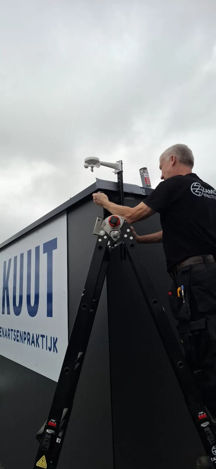 Elektricien aan het werk aan de gevel van Akuut